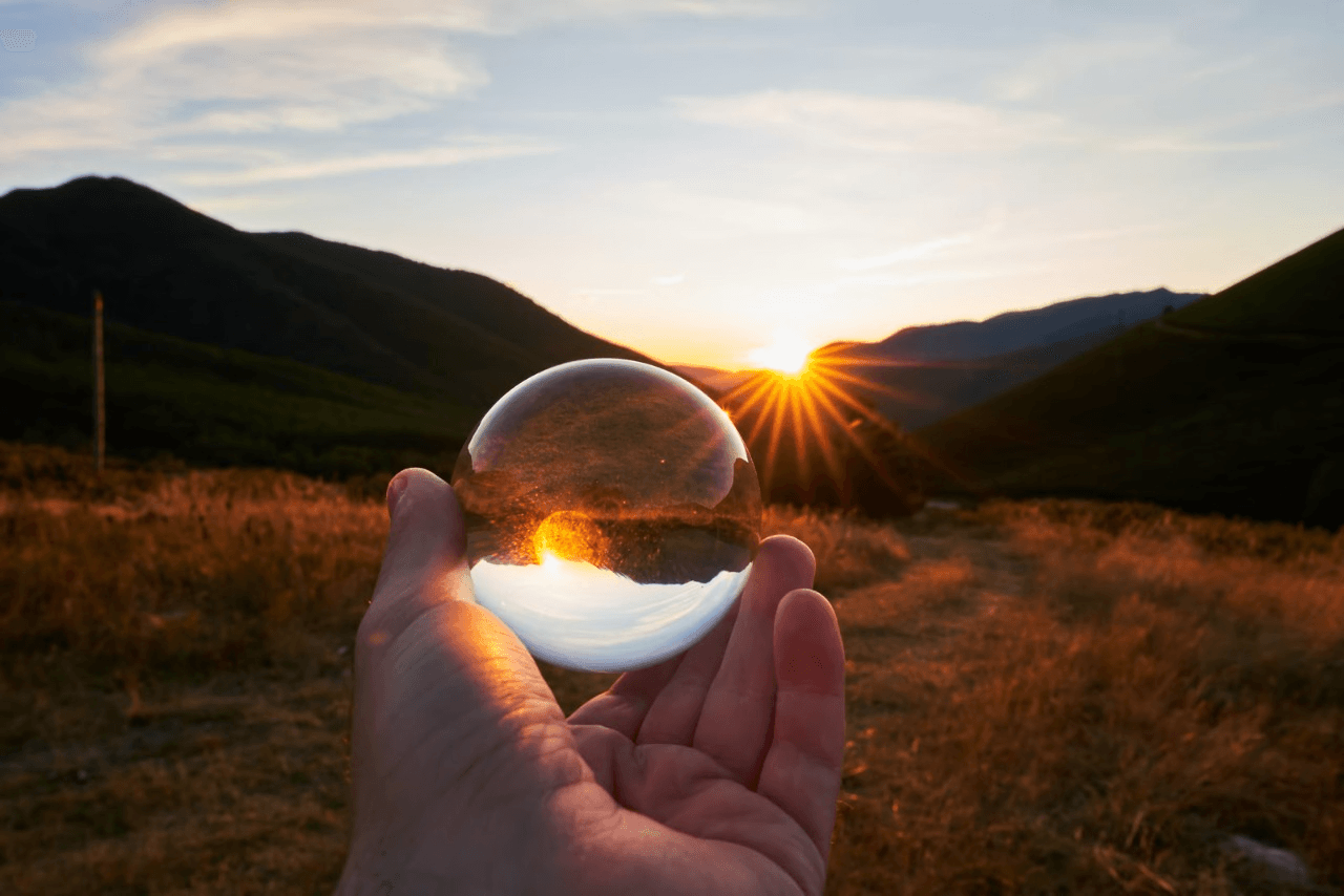 Sunset reflected in a handheld glass sphere.