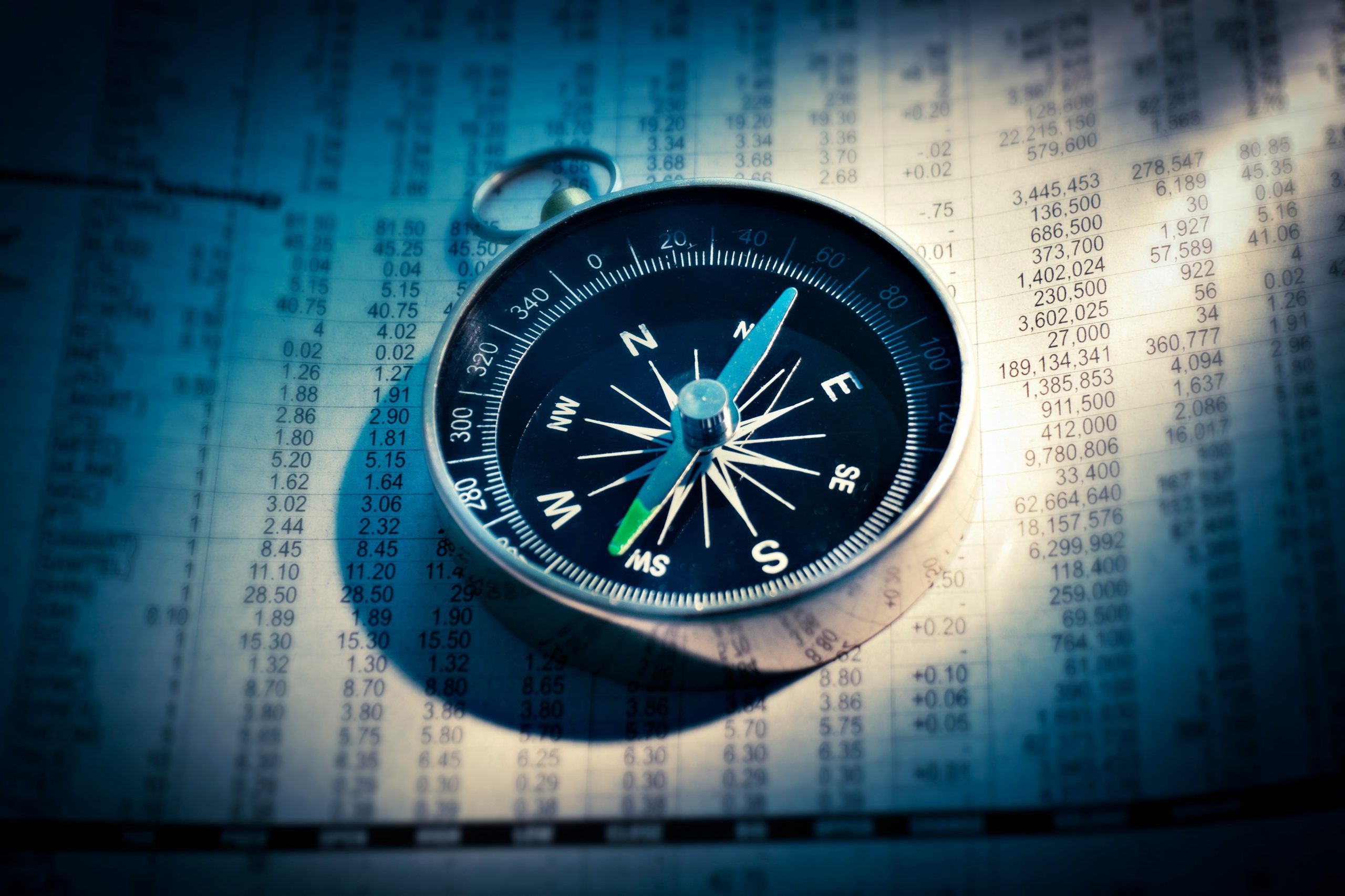 Compass on financial spreadsheet background